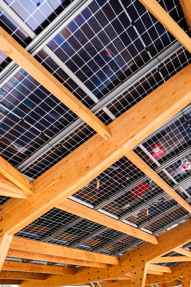 Carport Solaire en Bois : Ombrière Photovoltaïque Design Ombrière de parking en bois avec panneaux photovoltaïques intégrés pour production d'énergie solaire propre.