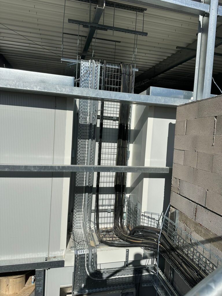 Installation de chemins de câbles électriques industriels Installation de chemins de câbles électriques industriels et câblage structuré dans un bâtiment en construction.