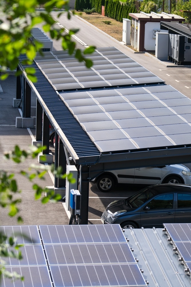 Ombrière photovoltaïque : parking et recharge solaire Ombrière de parking photovoltaïque avec panneaux solaires et bornes de recharge pour voitures électriques stationnées.